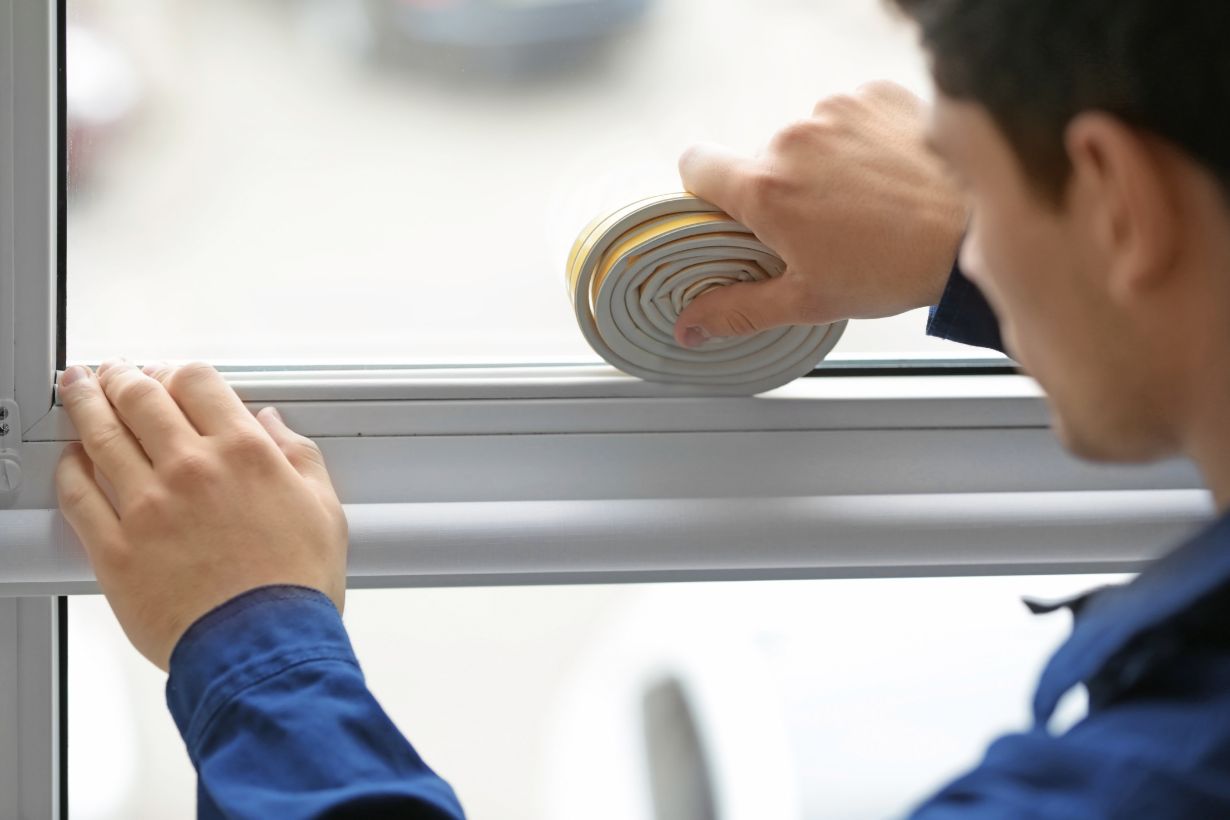 Man doing DIY window insulation