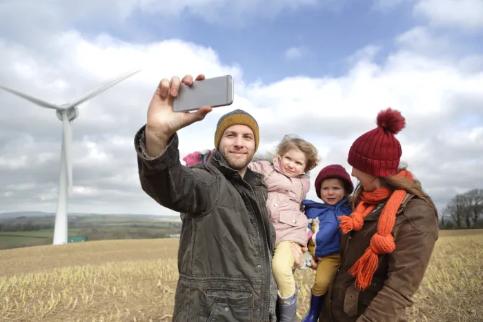 Family taking a selfie at a wind farm