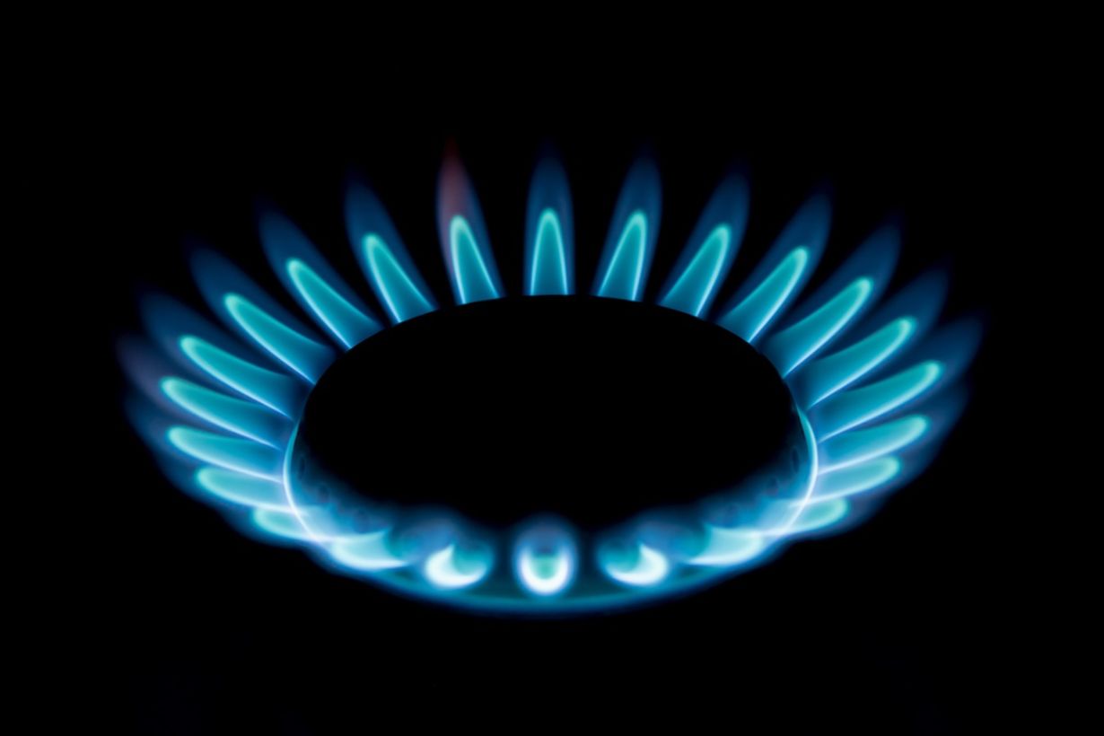 Close-up of blue flames burning on a gas hob.