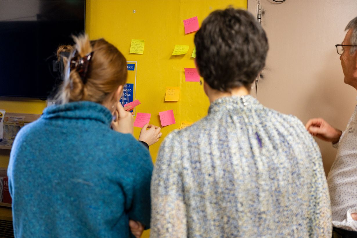 People adding feedback notes during a community energy workshop.