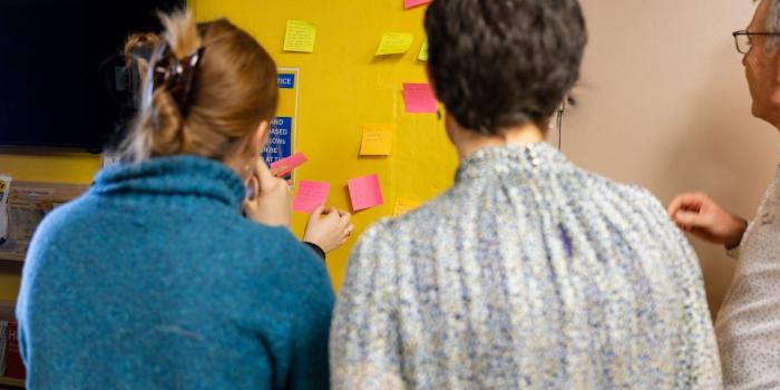 People adding feedback notes during a community energy workshop.