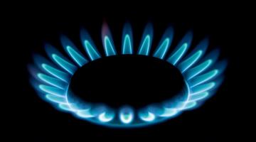 Close-up of blue flames burning on a gas hob.