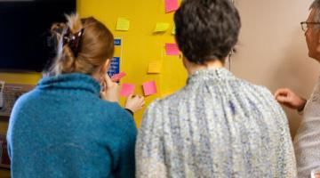 People adding feedback notes during a community energy workshop.